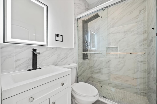 full bathroom featuring tile walls, vanity, a marble finish shower, and toilet