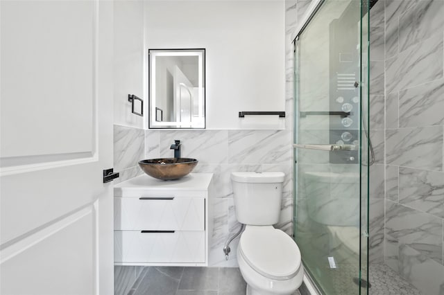 full bath featuring a wainscoted wall, toilet, tile walls, a stall shower, and vanity