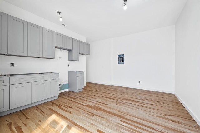 kitchen with gray cabinets, baseboards, and light wood-style flooring