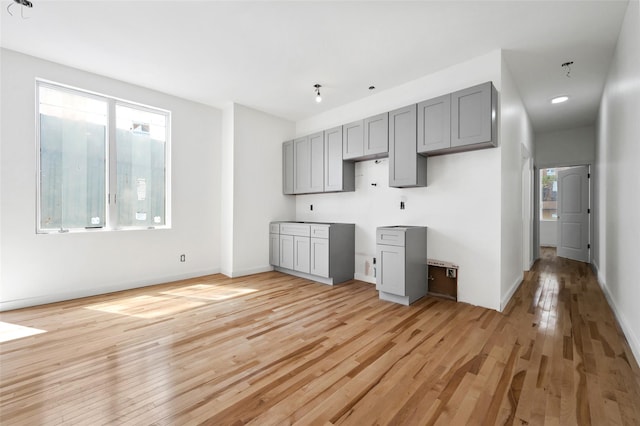 kitchen featuring gray cabinets, baseboards, and light wood-style flooring