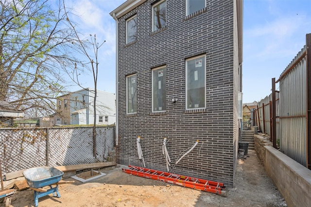 view of side of property with a fenced backyard and brick siding