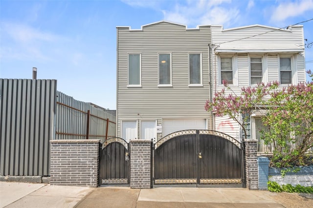 multi unit property with a gate, brick siding, a garage, and fence
