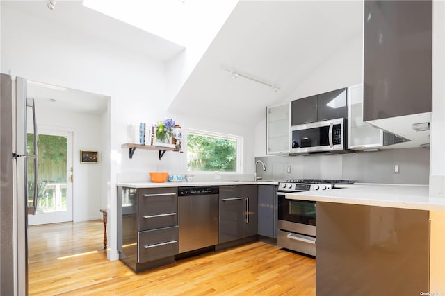 2955 Hyatt Rd, Southold, NY 11971 - kitchen with stainless steel appliances, modern cabinets, track lighting, light wood finished floors, and lofted ceiling