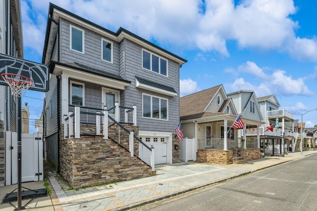 93 Nebraska St, Long Beach, NY 11561 - view of front of home with an attached garage, stone siding, concrete driveway, and a residential view