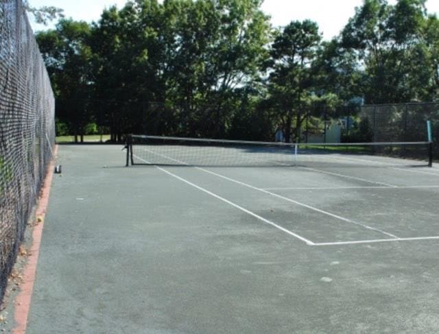 view of tennis court featuring fence