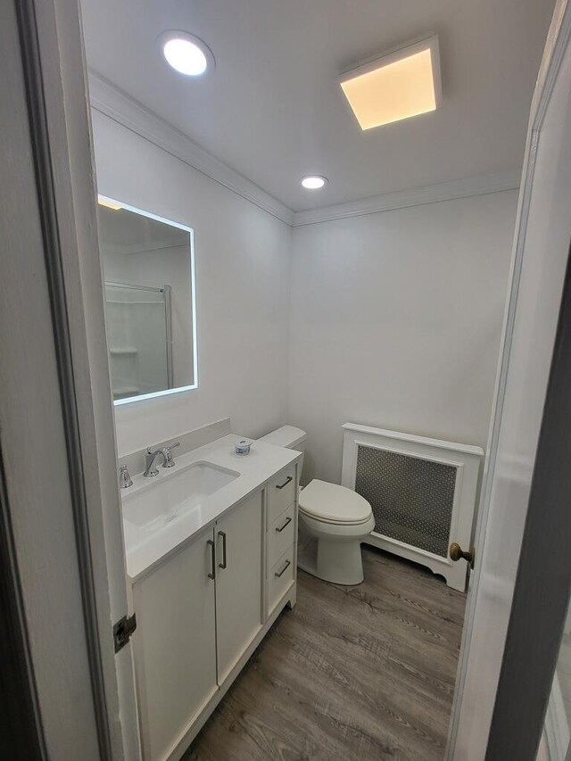 230 W Islip Rd, West Islip, NY 11795 - bathroom featuring radiator, crown molding, wood finished floors, vanity, and toilet