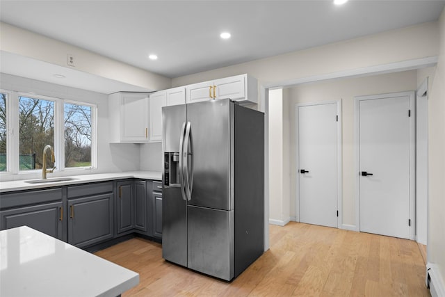 139 Cross Rd, Goshen, NY 10924 - kitchen featuring white cabinets, stainless steel fridge, a sink, light wood-type flooring, and gray cabinets