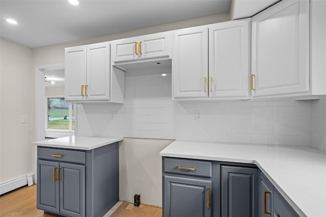 139 Cross Rd, Goshen, NY 10924 - kitchen featuring a baseboard heating unit, white cabinetry, and backsplash