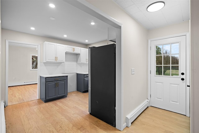 139 Cross Rd, Goshen, NY 10924 - kitchen with white cabinetry, freestanding refrigerator, light wood finished floors, and baseboard heating