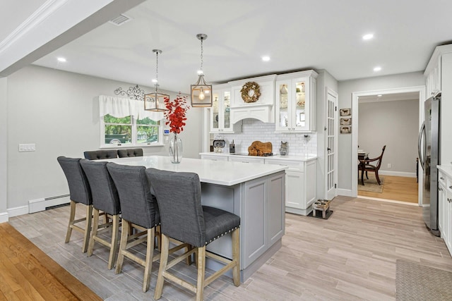 25 Macgregor Dr, Mahopac, NY 10541 - kitchen featuring a baseboard heating unit, freestanding refrigerator, light countertops, decorative backsplash, and white cabinets