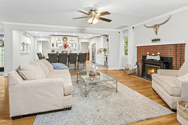 25 Macgregor Dr, Mahopac, NY 10541 - living area featuring ornamental molding, a ceiling fan, light wood-type flooring, and a brick fireplace