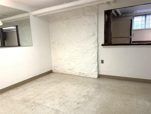 unfurnished room featuring baseboards and tile patterned floors