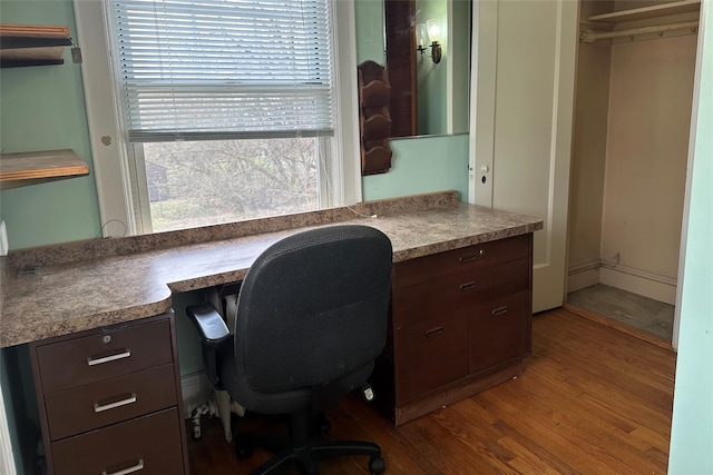office featuring built in desk and wood finished floors