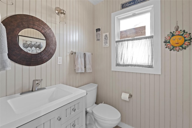 110 Ocean Rd, Ocean Beach, NY 11770 - bathroom featuring toilet, vanity, and wood walls