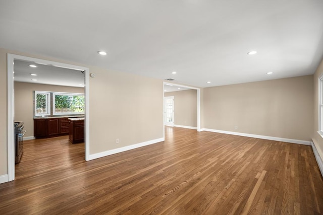 unfurnished living room featuring recessed lighting, baseboards, and wood finished floors