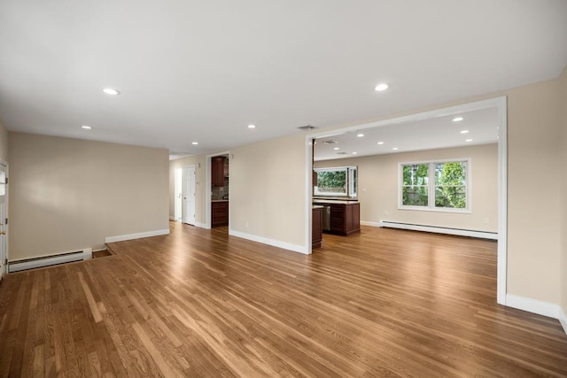 unfurnished living room featuring a baseboard radiator, a baseboard heating unit, light wood finished floors, and visible vents