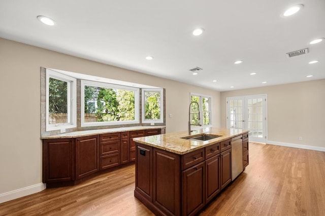 kitchen with stainless steel dishwasher, baseboards, visible vents, and a sink