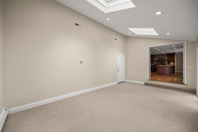 unfurnished living room with recessed lighting, lofted ceiling with skylight, and light colored carpet