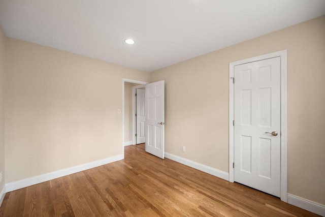 unfurnished bedroom with baseboards, recessed lighting, and light wood-type flooring