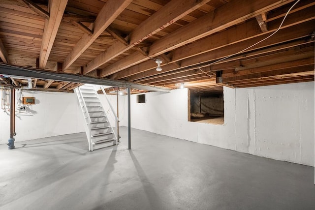 unfinished basement featuring stairway