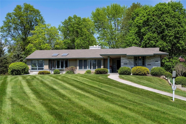 ranch-style home featuring a front yard and stone siding