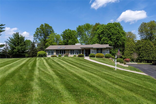 single story home featuring a front lawn