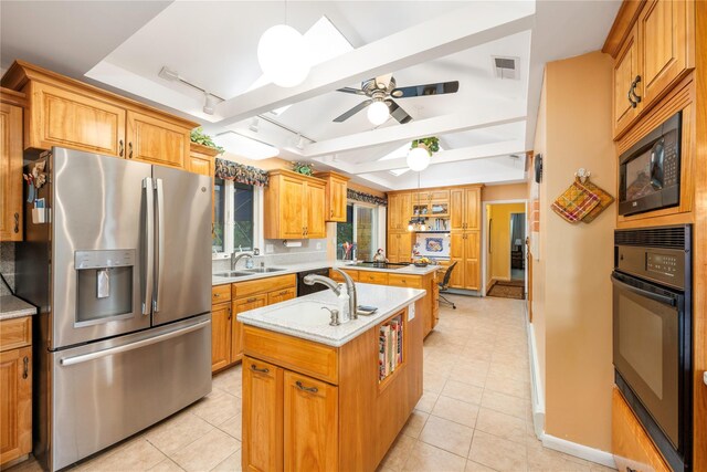 kitchen with black appliances, track lighting, an island with sink, a sink, and light tile patterned floors
