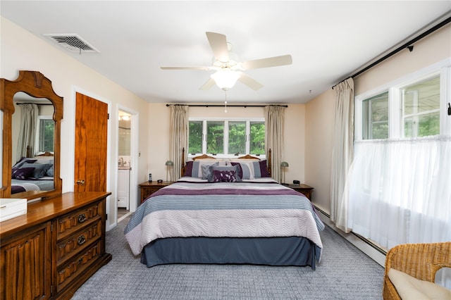 bedroom with a baseboard heating unit, ceiling fan, and connected bathroom