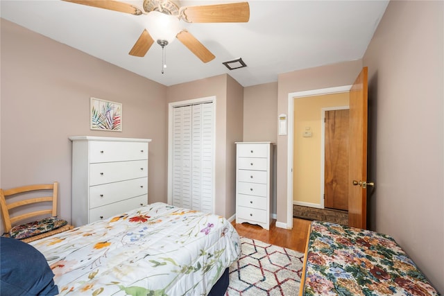 bedroom featuring wood finished floors, a closet, ceiling fan, and baseboards