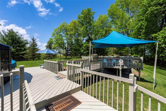 wooden terrace featuring a yard and view of wooded area
