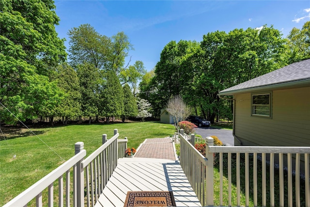 deck with a lawn, an outdoor structure, and view of scattered trees