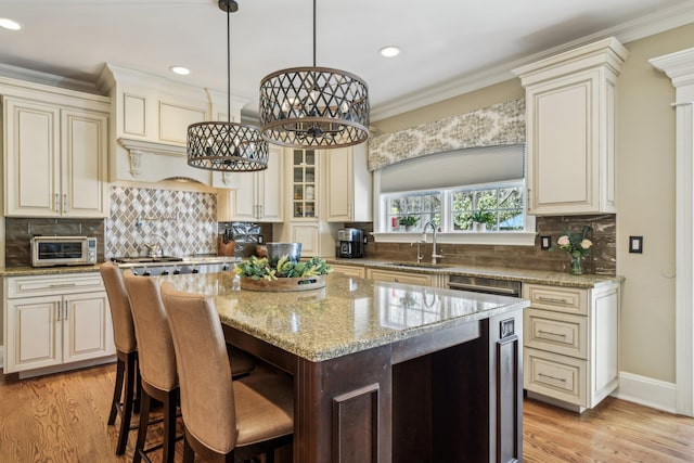 33 Bacon Rd, Saint James, NY 11780 - kitchen featuring light wood-style flooring, a center island, light stone countertops, ornamental molding, and tasteful backsplash