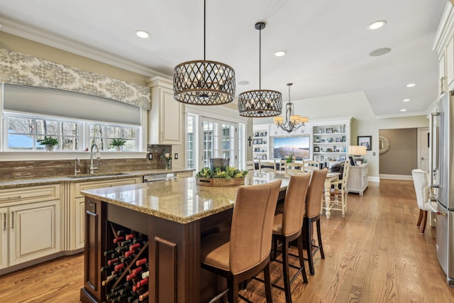 33 Bacon Rd, Saint James, NY 11780 - kitchen with cream cabinetry, stainless steel appliances, a chandelier, light stone counters, and a center island