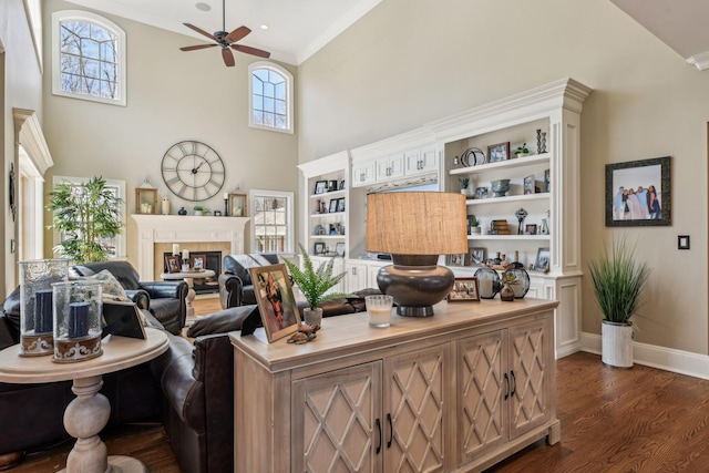 33 Bacon Rd, Saint James, NY 11780 - living room featuring a ceiling fan, dark wood-style floors, ornamental molding, a towering ceiling, and a glass covered fireplace