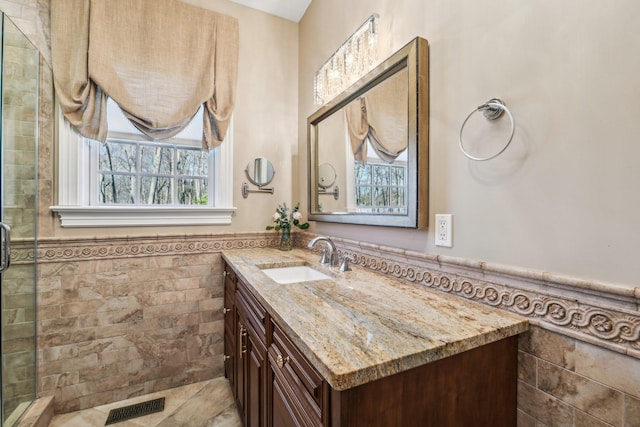 33 Bacon Rd, Saint James, NY 11780 - bathroom with tile walls, vanity, wainscoting, and a stall shower