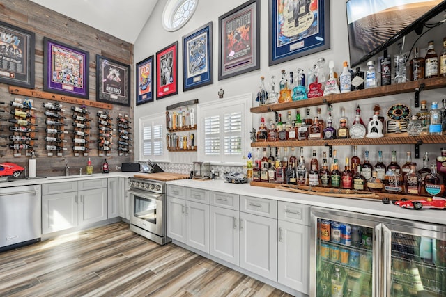 33 Bacon Rd, Saint James, NY 11780 - indoor bar with appliances with stainless steel finishes, wine cooler, high vaulted ceiling, and light wood-style flooring