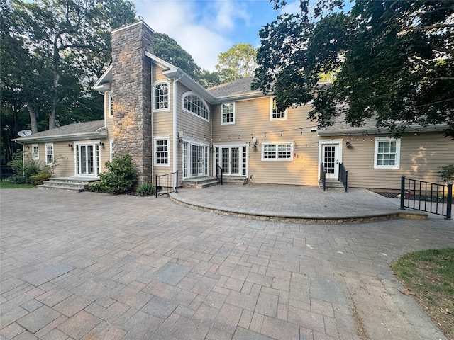 33 Bacon Rd, Saint James, NY 11780 - back of house with entry steps, a chimney, and a patio area