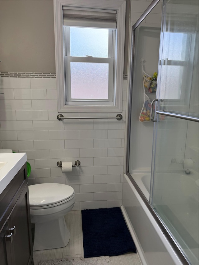 647 Lincoln St, Baldwin Harbor, NY 11510 - bathroom featuring tile walls, vanity, toilet, and enclosed tub / shower combo