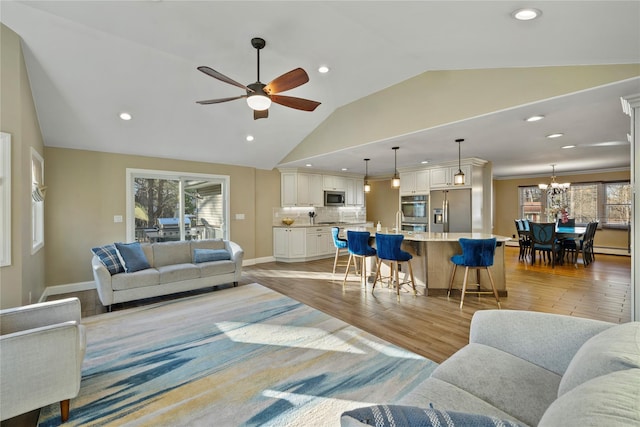 3 Bell Ct, Airmont, NY 10901 - living area featuring a healthy amount of sunlight, light wood finished floors, ceiling fan with notable chandelier, and lofted ceiling