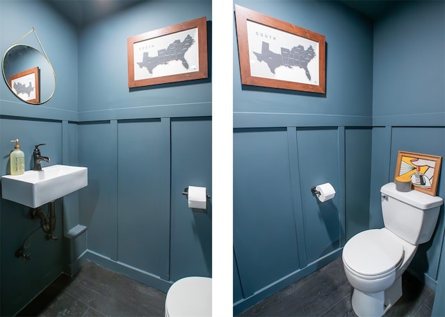bathroom featuring a sink, toilet, a decorative wall, wainscoting, and wood finished floors