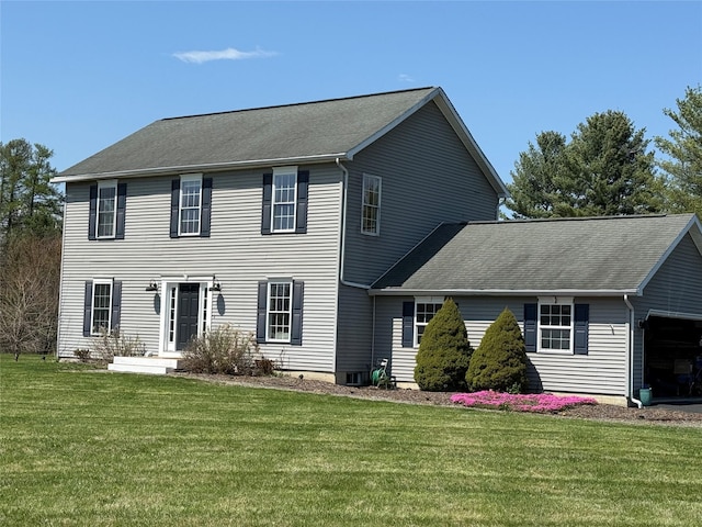 colonial house with a front yard, a shingled roof, and a garage
