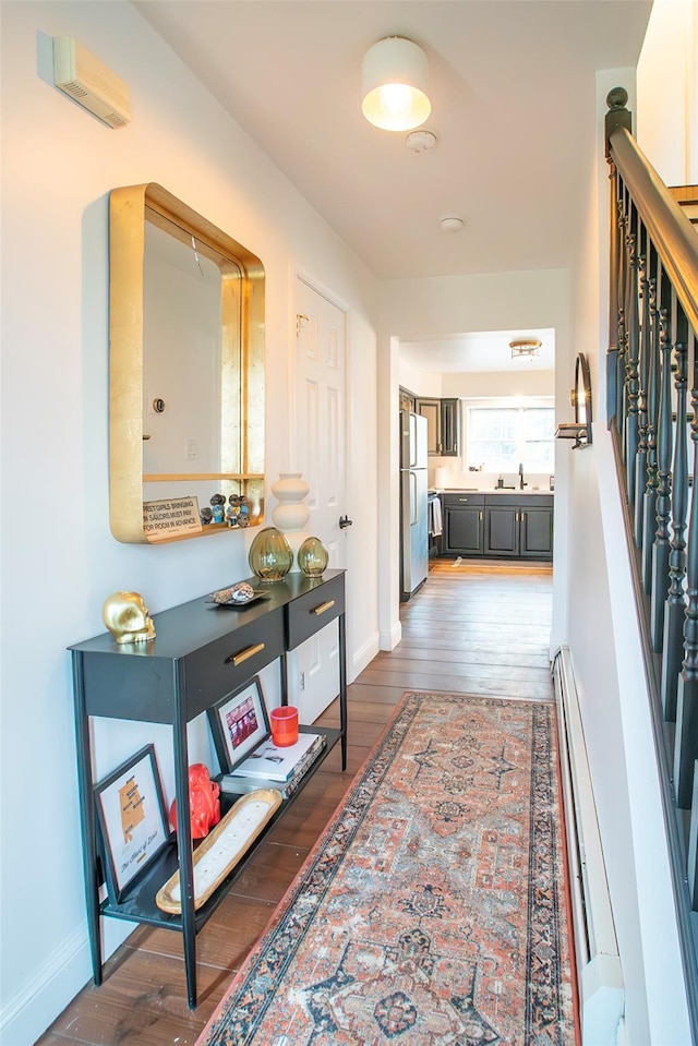 49 Macintosh Dr, Hudson, NY 12534 - hallway featuring a sink, dark wood-type flooring, stairs, and baseboards