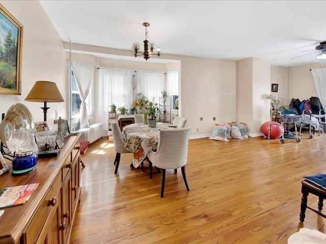 dining space featuring baseboards, a notable chandelier, and light wood finished floors