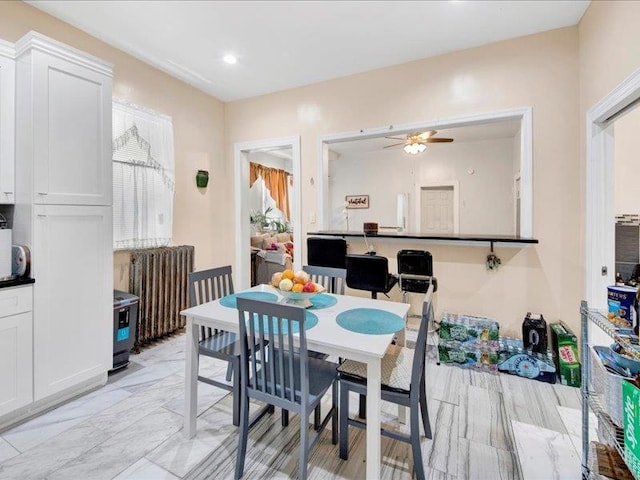dining space featuring radiator heating unit, a ceiling fan, and recessed lighting