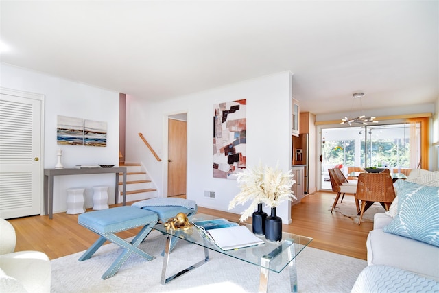 435 Carol Pl, Pelham, NY 10803 - living room with light wood-type flooring, an inviting chandelier, visible vents, and stairway