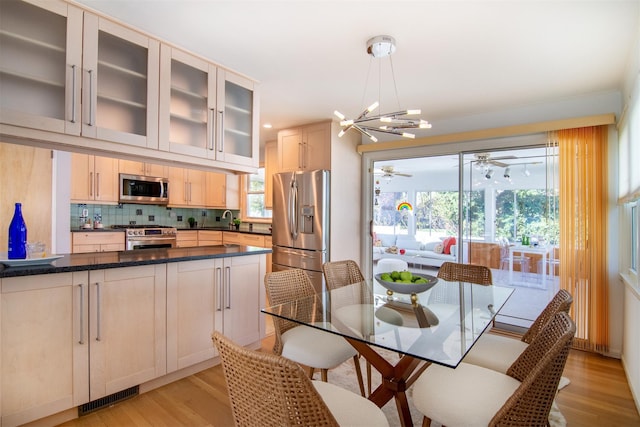 435 Carol Pl, Pelham, NY 10803 - dining room featuring visible vents, ceiling fan with notable chandelier, light wood finished floors, and a healthy amount of sunlight