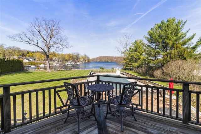 wooden terrace with a lawn and a water view