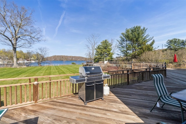 wooden terrace with a water view, a yard, and area for grilling