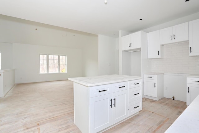 334NOhioville Rd, New Paltz, NY 12561 - kitchen with white cabinets, backsplash, light wood-type flooring, light stone countertops, and open floor plan