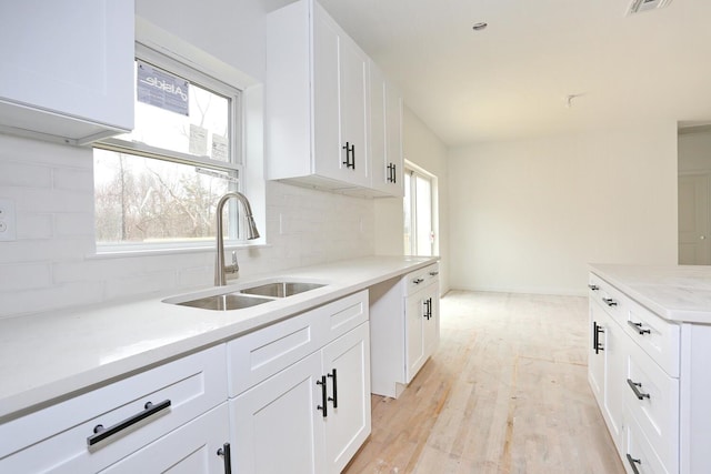 334NOhioville Rd, New Paltz, NY 12561 - kitchen featuring tasteful backsplash, a sink, light wood finished floors, light countertops, and white cabinets